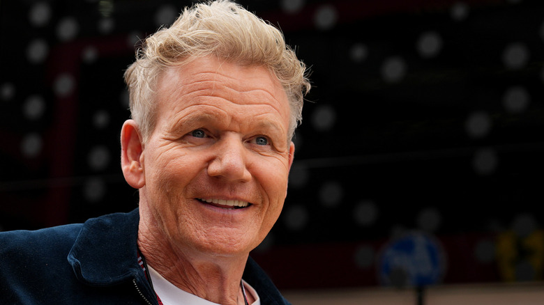 Gordon Ramsay smiling while wearing a blue jacket.