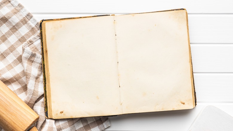 old cookbook opened to blank pages