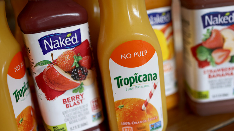 Bottles of Tropicana orange juice and Naked Juice berry blast next to each other