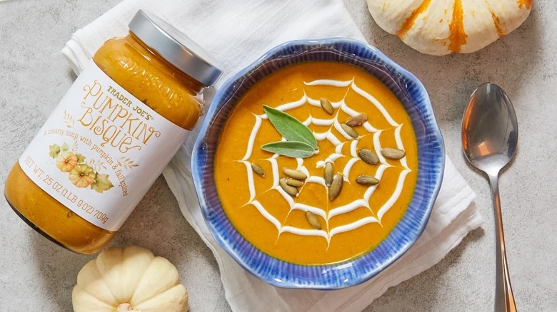 Trader Joe's pumpkin bisque in a jar and in a bowl topped with seeds