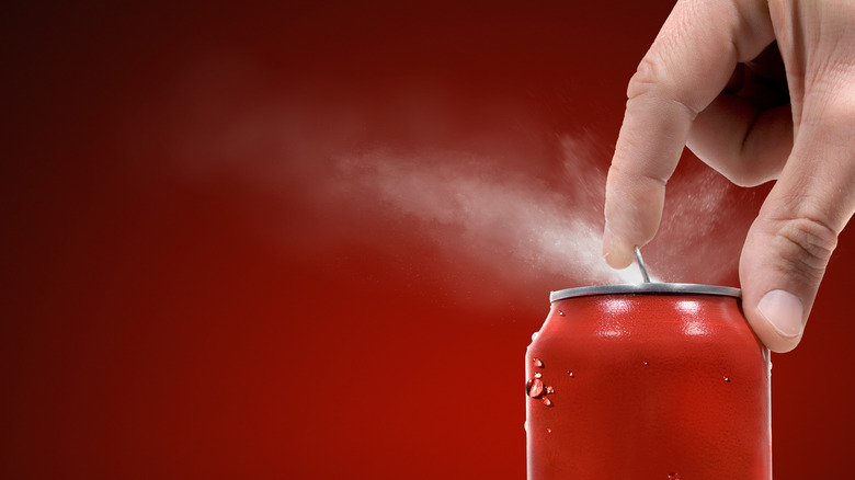 A can of soda being opened