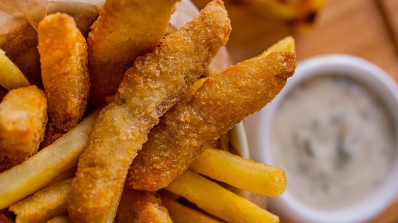 Pieces of fried fish, arranged with fries.