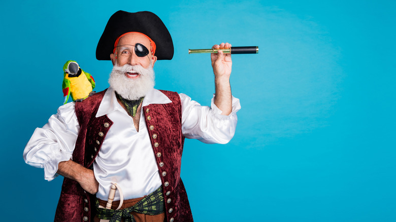Bearded man wearing pirate costume.