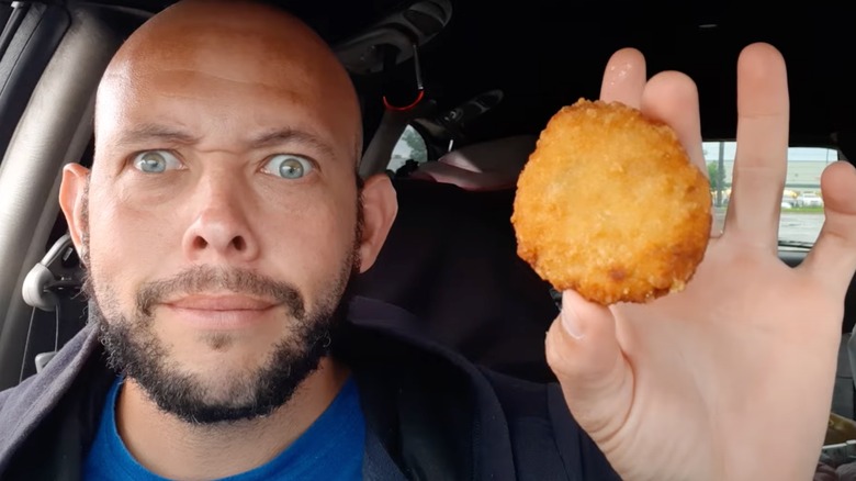 Man holding up Long John Silver's crab cake.