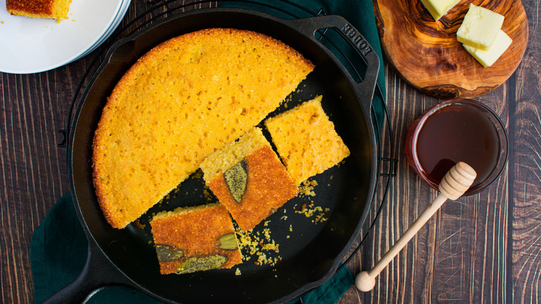 Cornbread in a cast iron skillet, with some squares cut