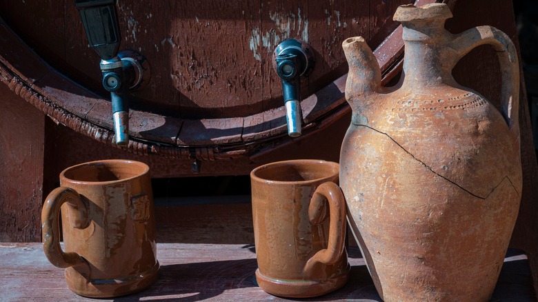 Amphora with mugs and wine barrel