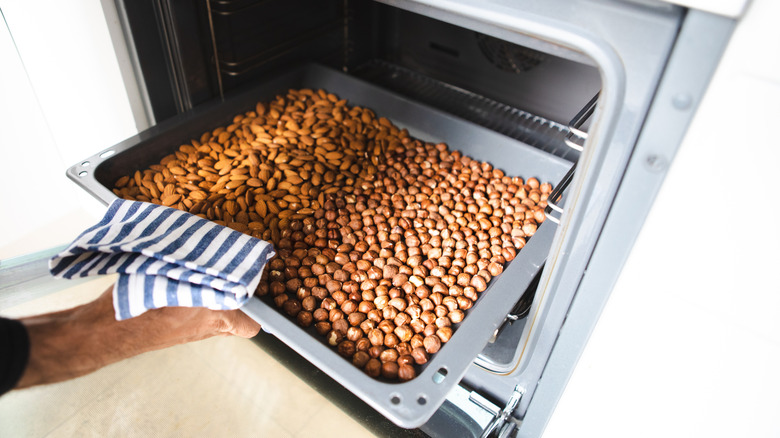 Hazelnuts and almonds roasting on oven tray