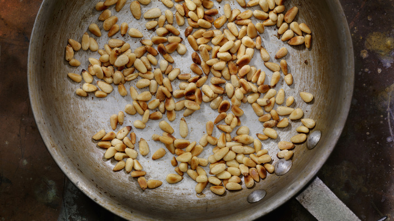 Toasted pine nuts in frying pan