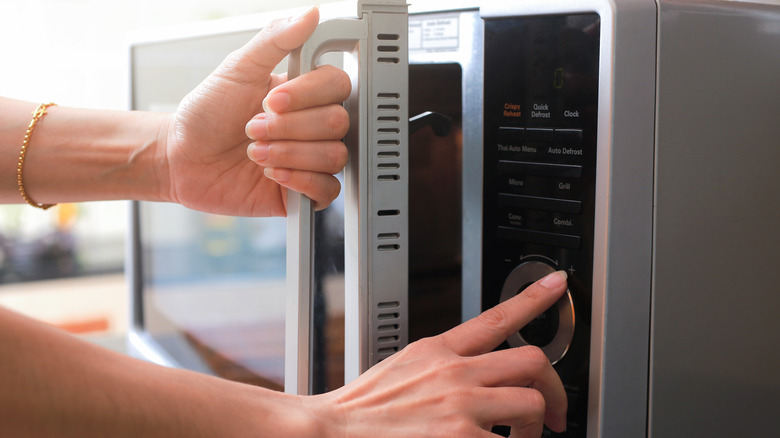 person opening microwave oven