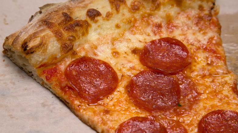 Slice of pepperoni pizza on a paper plate