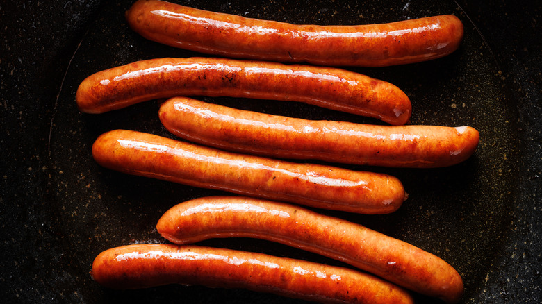 hot dogs cooking in pan