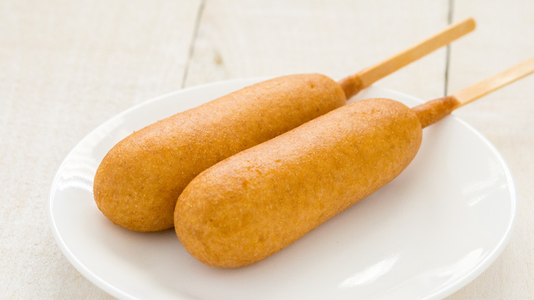 Two corn dogs on white plate