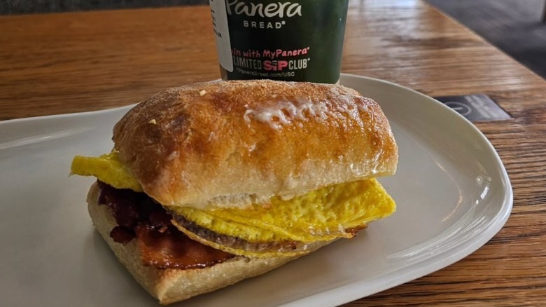 Panera bread bacon, egg, and cheese sandwich on a plate placed on a table