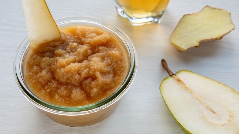 pureed pear in glass bowl with fresh pear slices
