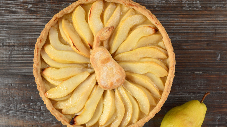 pear tart with circular fruit design and decorative pear cookie