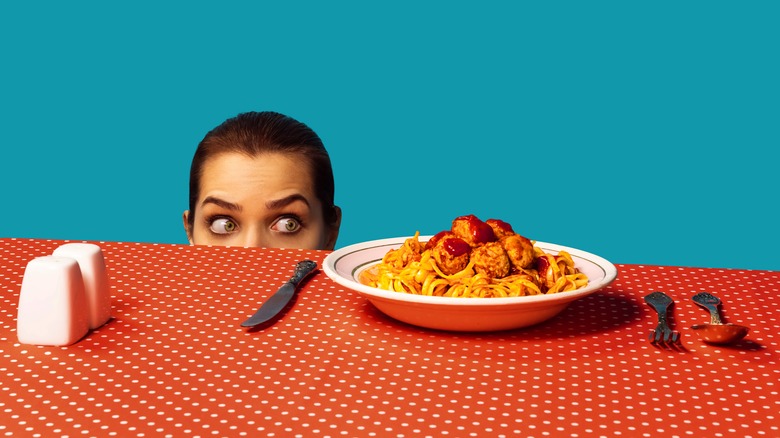Woman eyeing huge pasta bowl