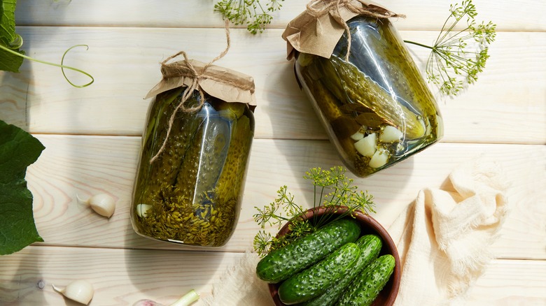 pickles in glass jars on rustic background