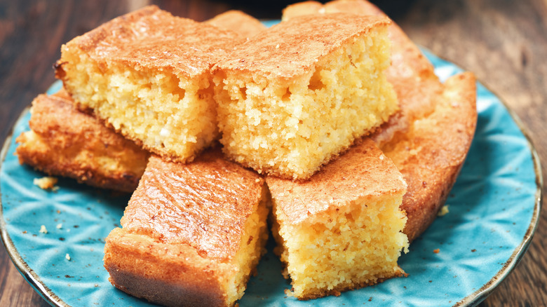 Cornbread squares stacked on blue plate