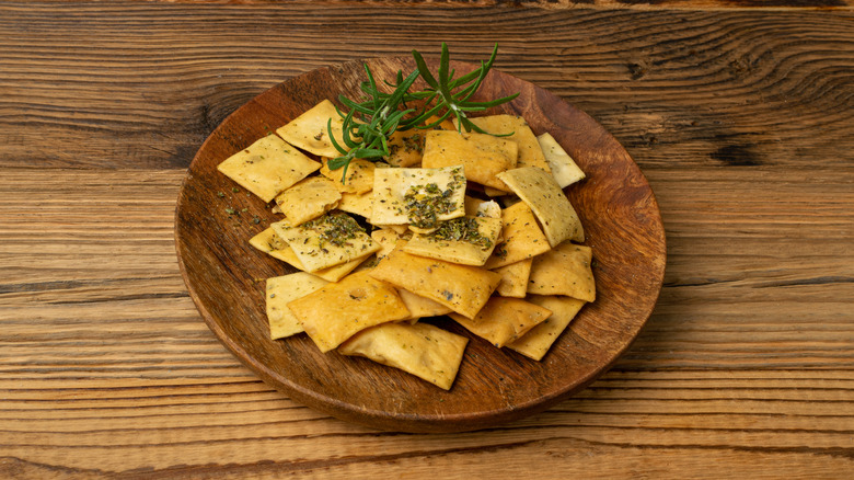 Pita chips on round wooden plate
