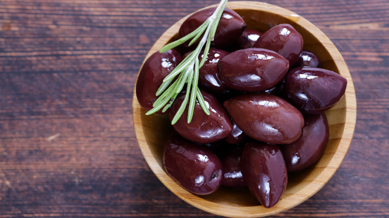 Small wooden bowl of Kalamata olives