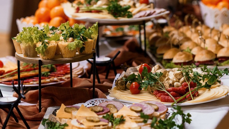 a spread of party food with charcuterie and burgers