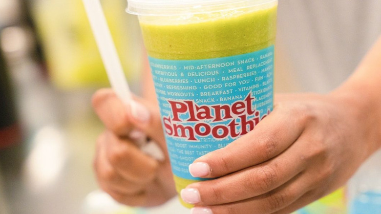 Hand holding Planet Smoothie cup