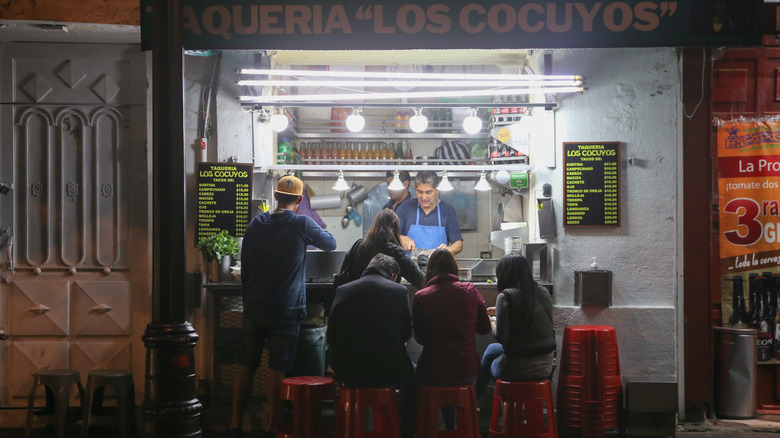 Customers sit outside of a taqueria