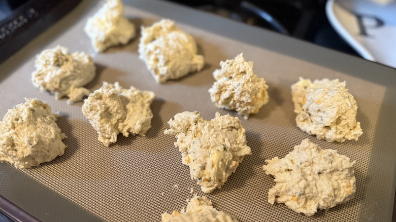 Mounds of biscuit dough on a cookie sheet