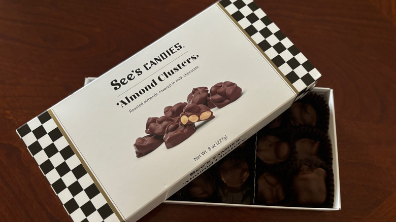 A box of See's Candies Almond Clusters with a checkerboard and white box