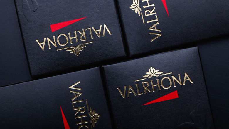 Black boxes with "Valrhona" and the company logo printed in gold; the logo is also embossed in the corner