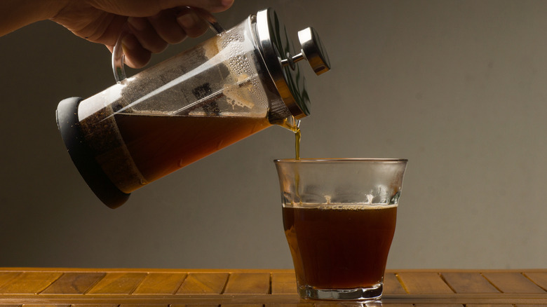 Coffee poured from French press to glass