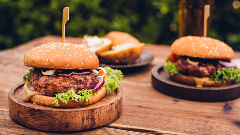 Hamburgers on wood plates outdoors