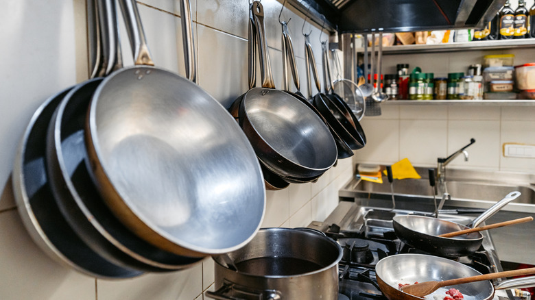 different kinds of pans hanging on kitchen wall