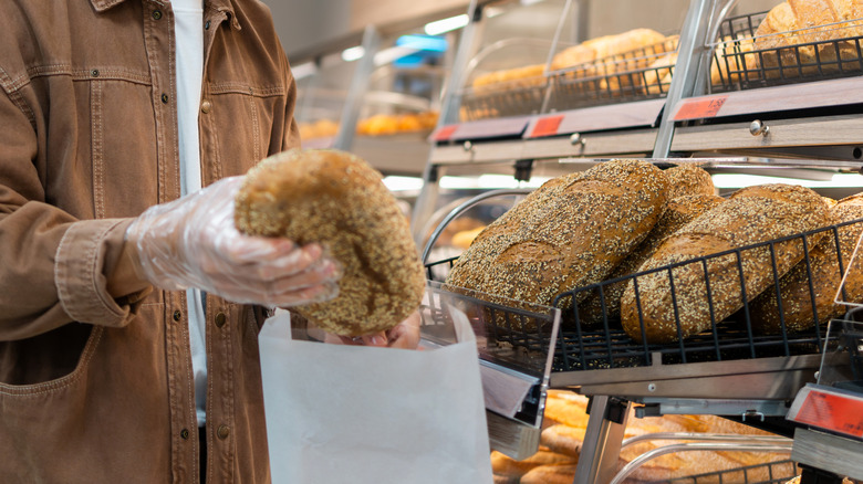 A shopper choosing bread at a bakery