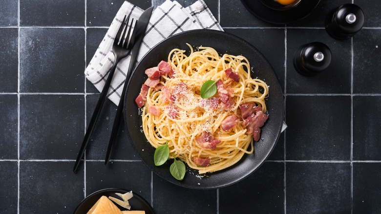 A dish of carbonara with knife and fork