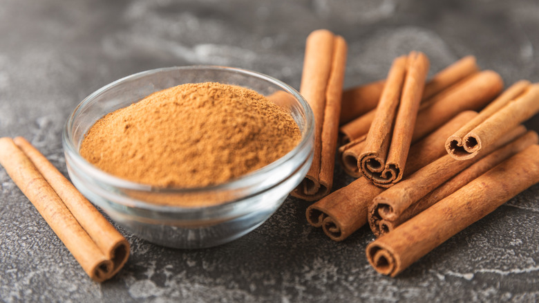 Cinnamon sticks and powder in ramekin