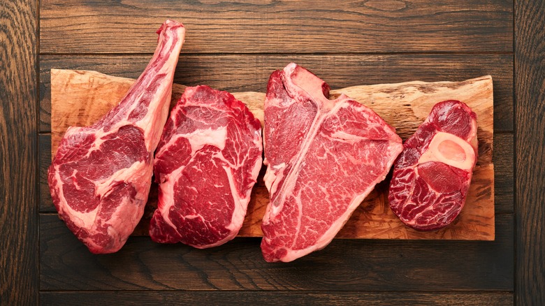 Several steaks on cutting boards