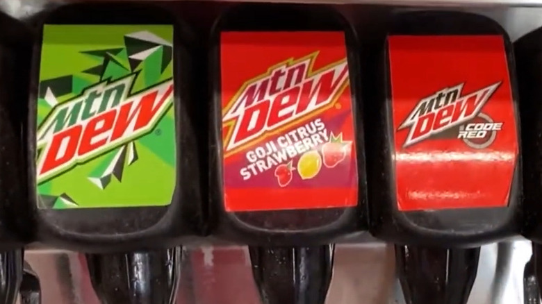 A closeup of a soda fountain featuring Mountain Dew, Mountain Dew Goji Citrus Strawberry, and Mountain Dew Code Red