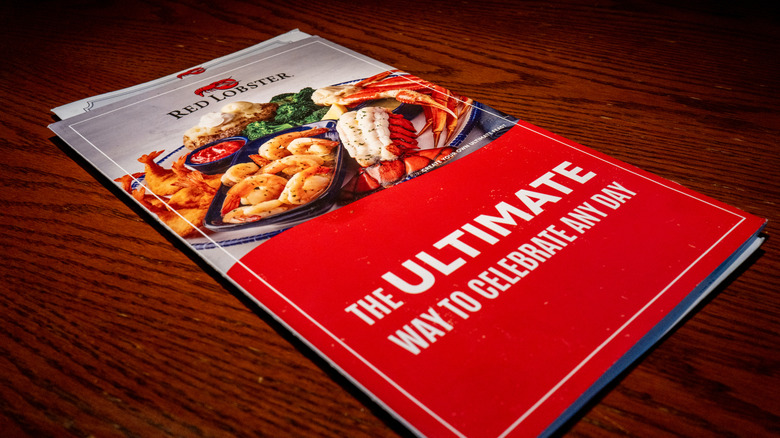 a Red Lobster menu with a large red bottom on a wooden table