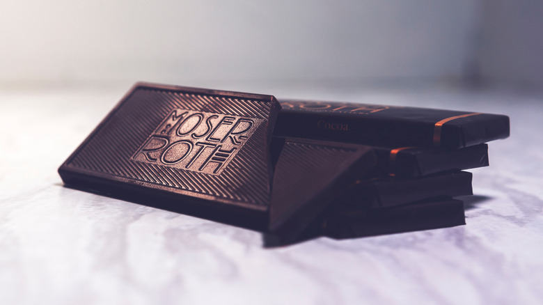 A Moser Roth chocolate bar with the logo on it, in front of wrapped bars
