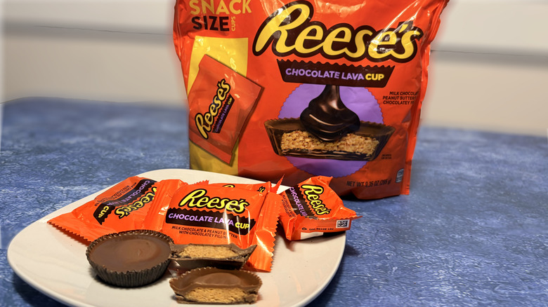 Reese's lava cup sliced in half on a plate, in front of the product package