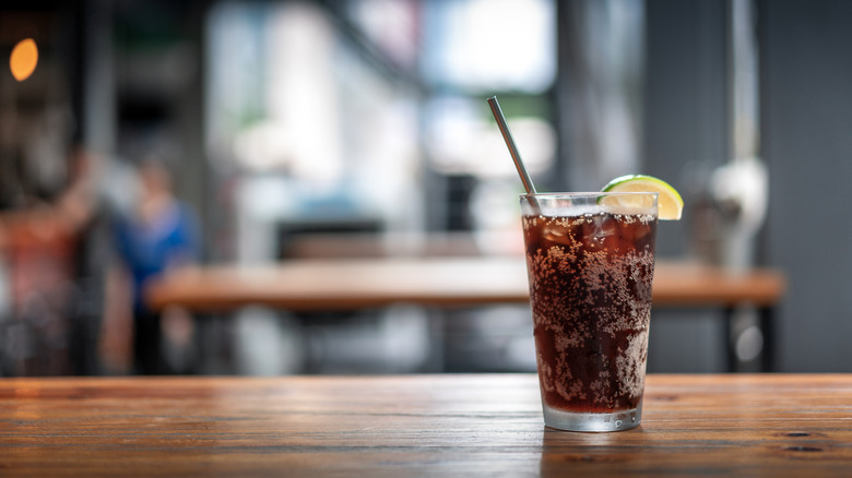 A glass of Coke on a table.