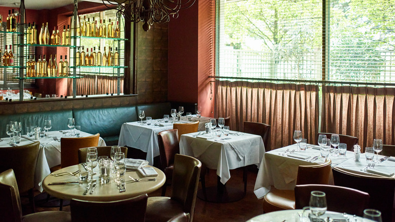 A restaurant dining room with the tables set for service