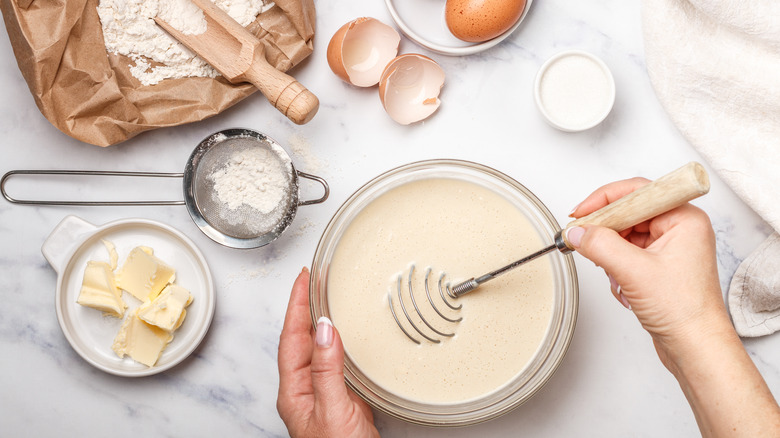 Mixing pancake batter surrounded by various ingredients