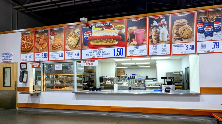 Interior of a Costco food court, with the menu items displayed above the counter