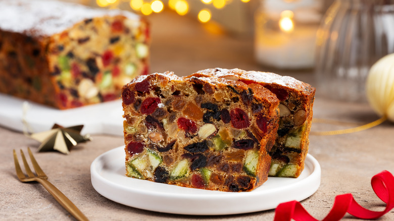 Christmas fruitcake in a white plate, placed on a table with a fork on the side