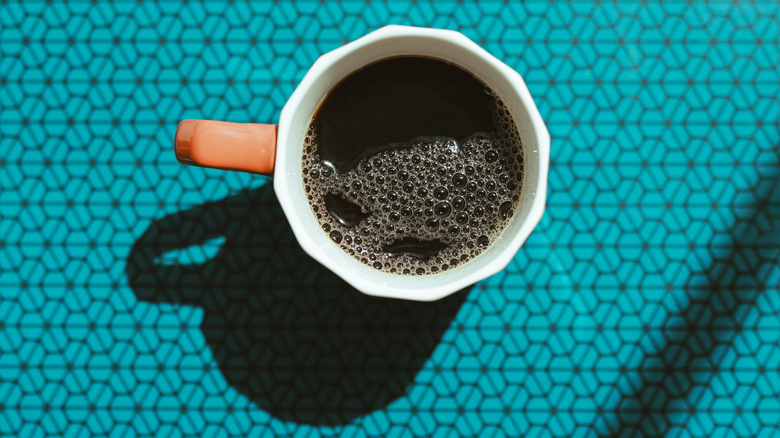 Overhead view of a mug of black coffee