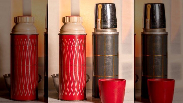 A pair of vintage thermos flasks and cups posed on a countertop