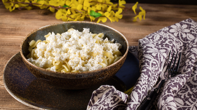 A bowl of pasta covered in cottage cheese