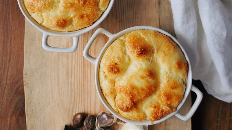 Onion soufflés in ramekins on wooden table
